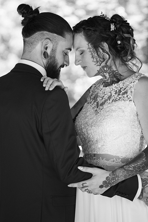 Photo en noir et blanc d'un couple de mariés partageant un moment complice, symbolisant la spontanéité et la confiance